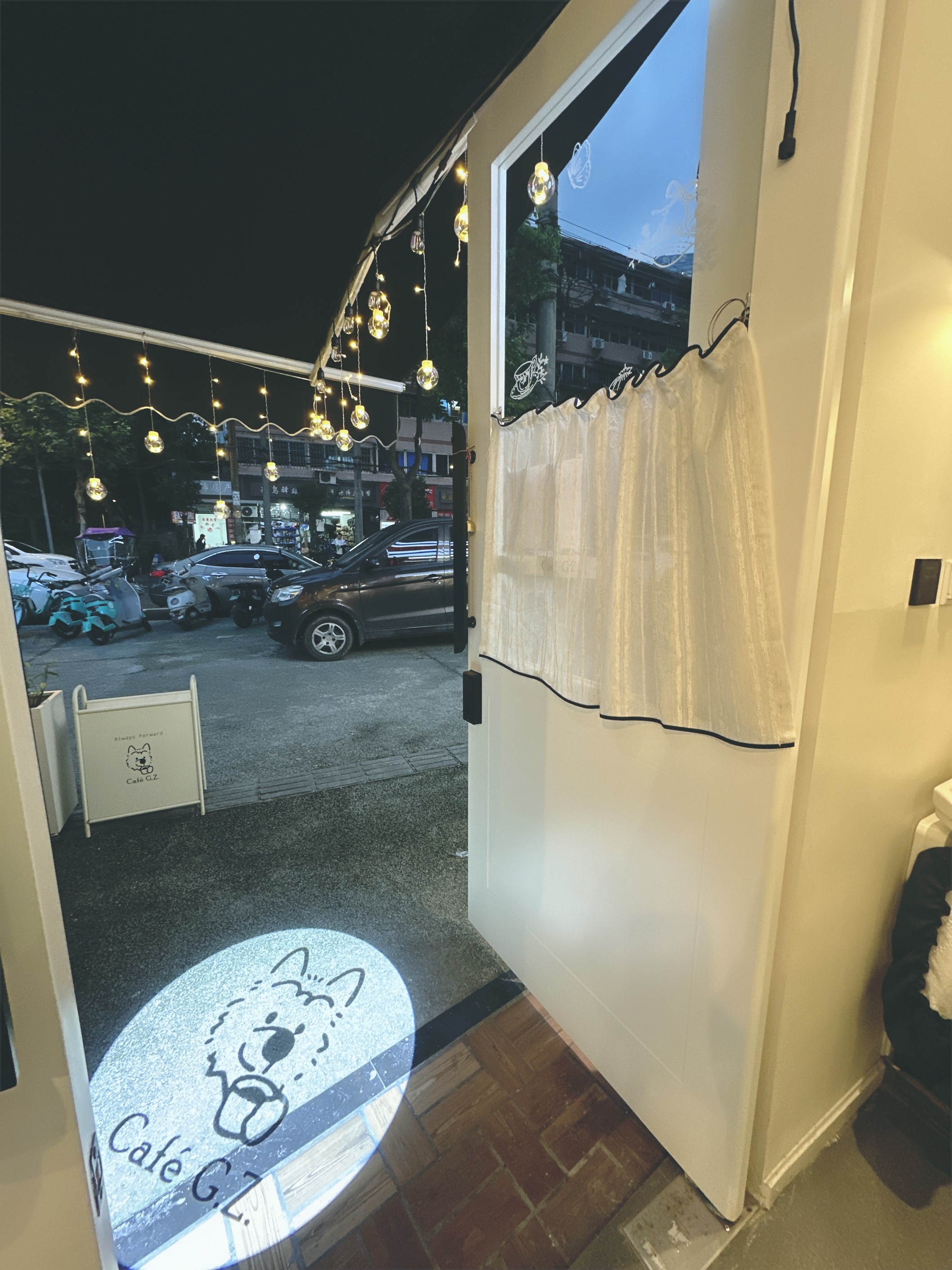 从 Café G.Z. 门内看向入口，地面有品牌小狗投影